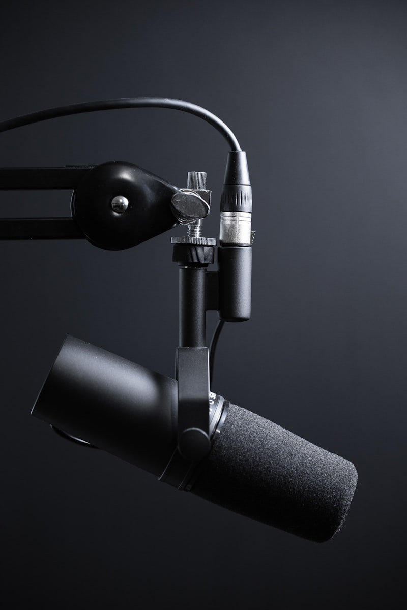 Persona hablando ante un micrófono profesional en un estudio moderno de videopodcast con auriculares
